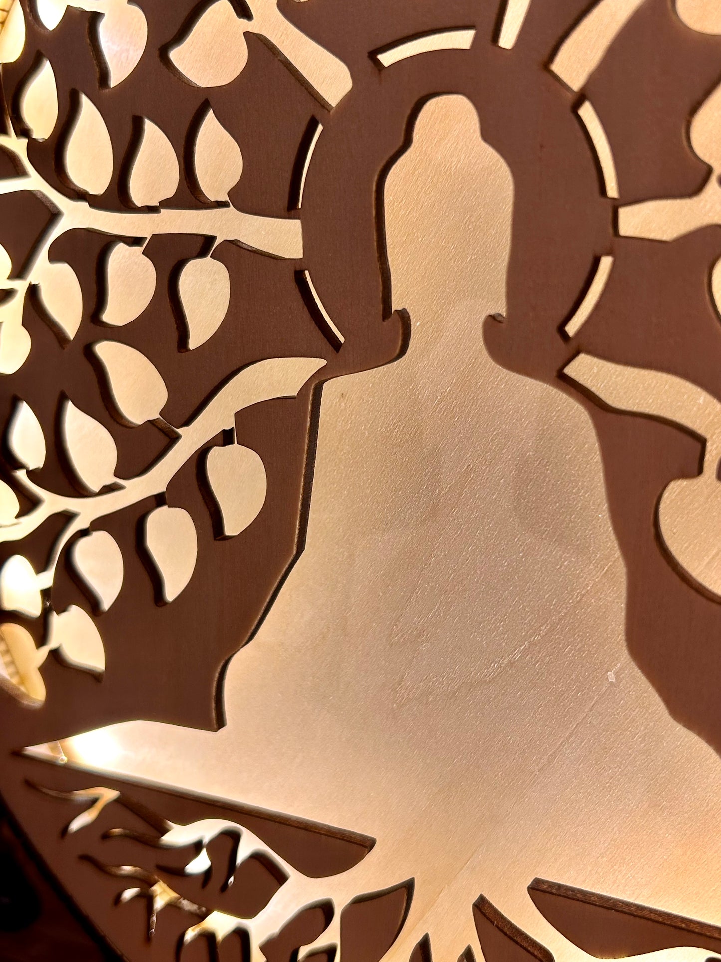 Silhouette lumineuse d’un bouddha au pied d’un arbre